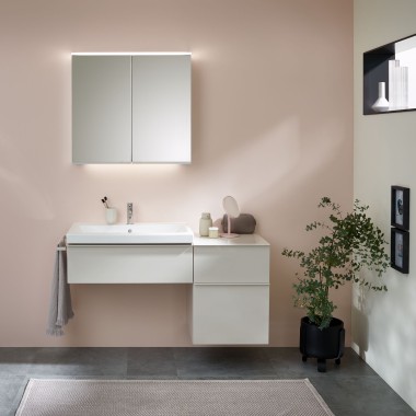 Wastafel met badkamermeubel, wastafel en spiegelkast van Geberit voor een pastelkleurige muur