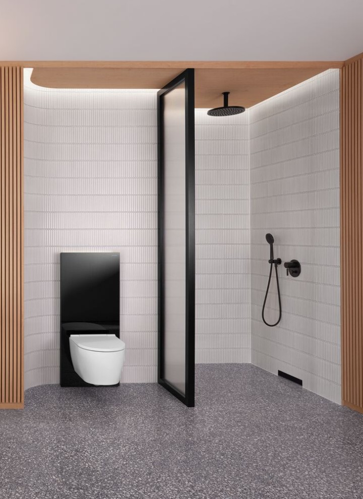 Een badkamer met een houten wand en een douche- en toiletruimte in zwart-wit