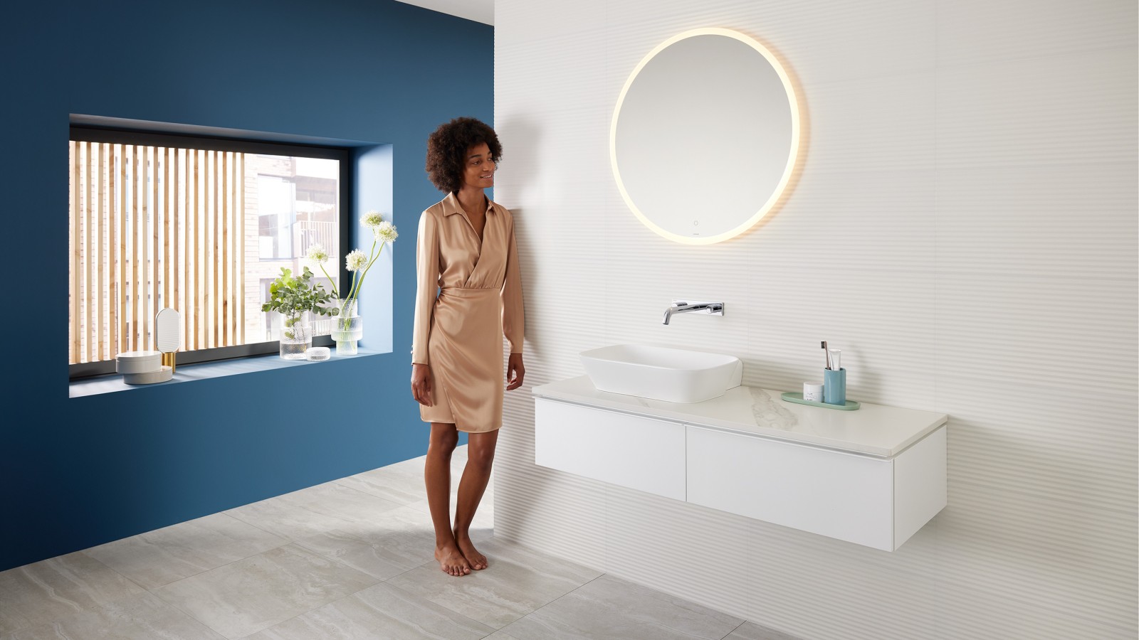 Een vrouw leunt tegen de muur in een badkamer met Geberit producten uit het Mix & Match assortiment. Een vrouw leunt tegen de muur in een badkamer met Geberit producten uit het Mix & Match assortiment.