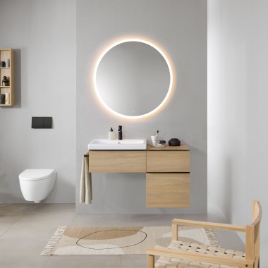 Badkamer met grijze muren, Geberit badkamermeubels in hout en een ronde Geberit Option verlichte spiegel