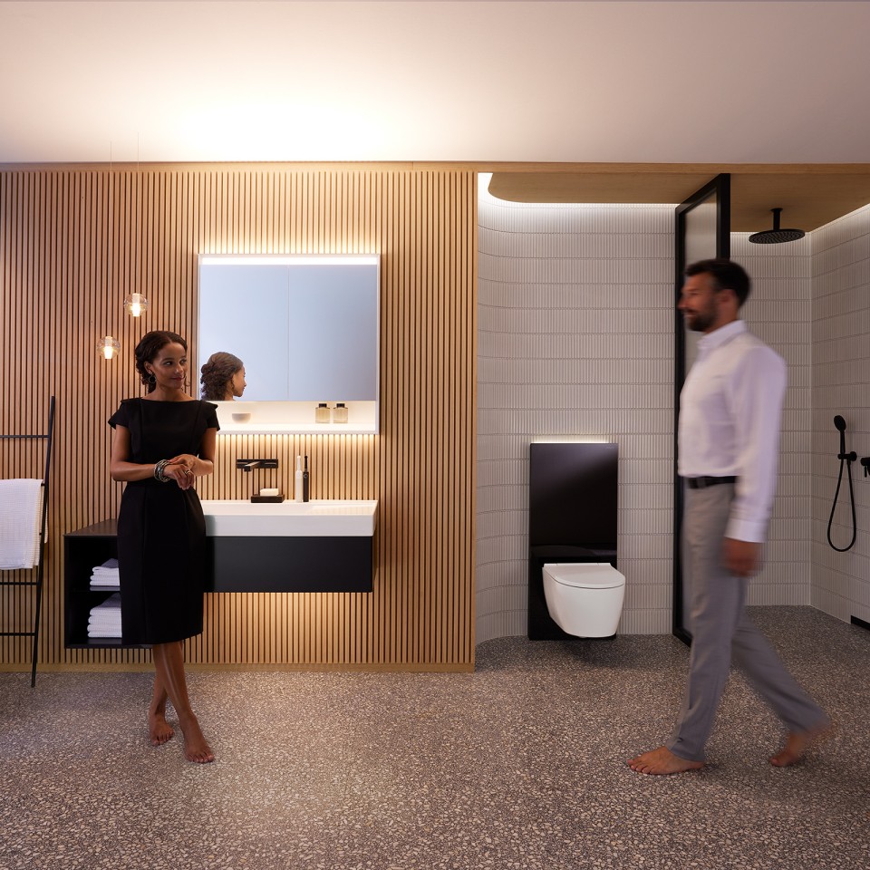 Man en vrouw in de harmonieus verlichte badkamer met Geberit ONE badkamermeubels en keramiek (© Geberit)