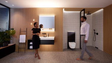 Man en vrouw in de harmonieus verlichte badkamer met Geberit ONE badkamermeubels en keramiek (© Geberit)