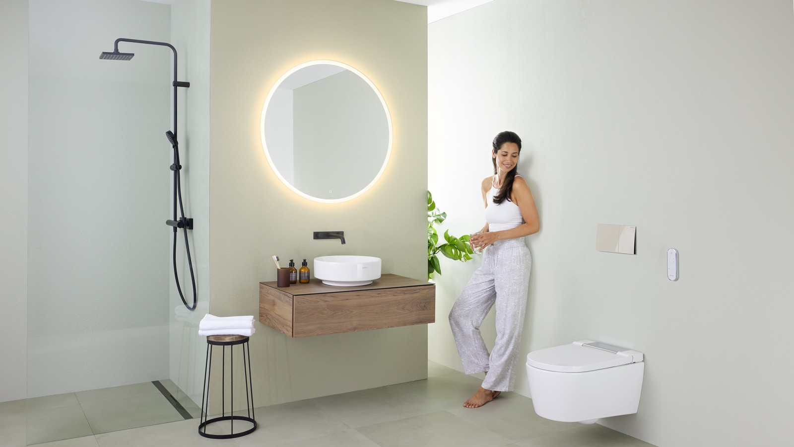 Vrouw in een badkamer met een minimalistische inrichting Vrouw in een badkamer met een minimalistische inrichting