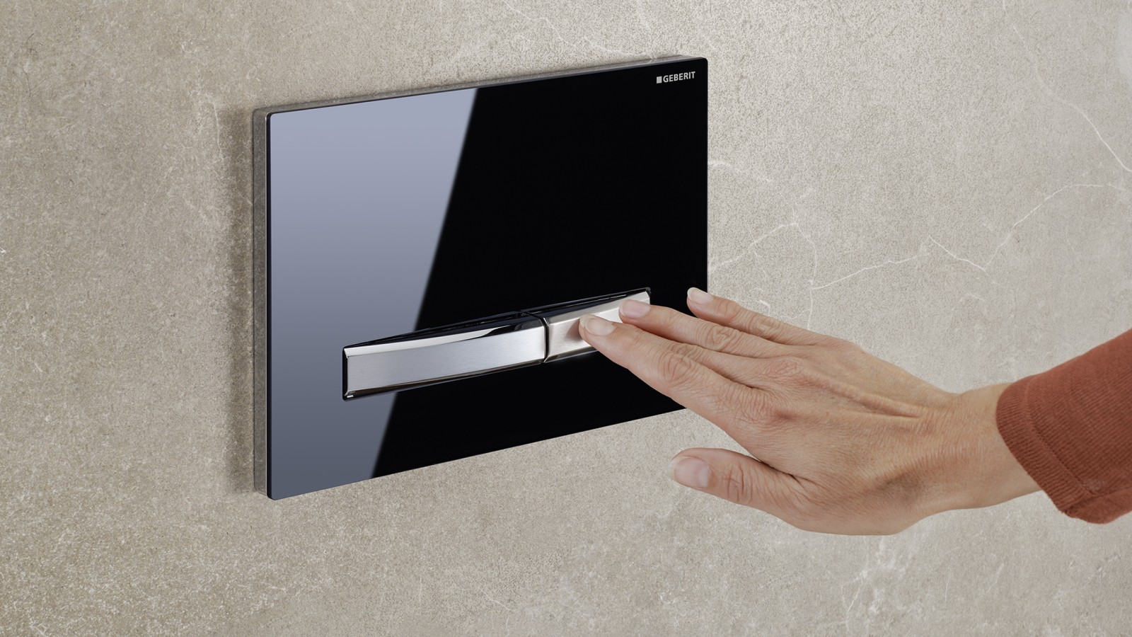Met de hand op de kleine toest van de Geberit Sigma50 bedieningsplaat drukken Met de hand op de kleine toest van de Geberit Sigma50 bedieningsplaat drukken