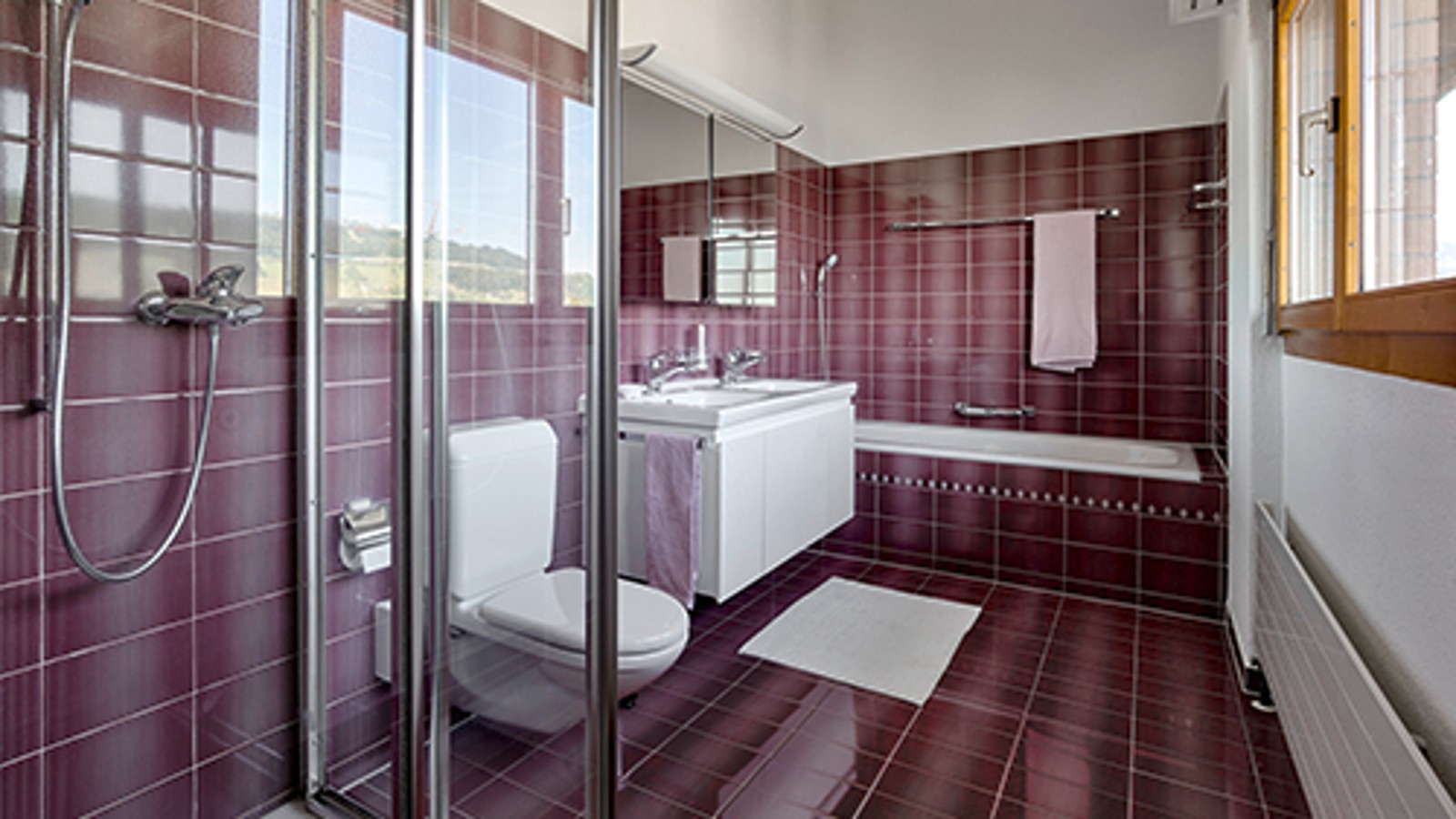 Badkamer voor renovatie met rode tegels