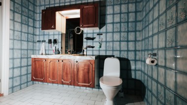 Badkamer met blauwe tegels en vloerstaande wc