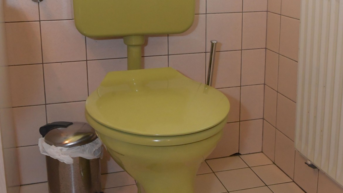 De oude wc met opbouwreservoir in het gastentoilet