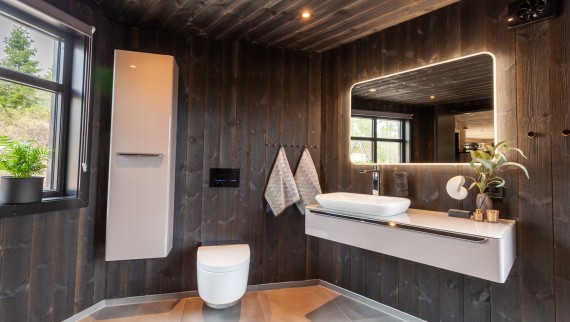 Ook de badkamer is met hout afgewerkt. Naast de AquaClean douche‑wc Mera zijn hier diverse andere Geberit producten zichtbaar (© Geberit)
