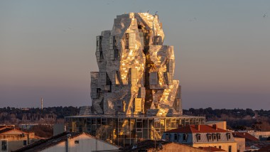 De speciaal gecoate aluminium panelen van de torengevel reflecteren het licht van de avondzon en creëren zo een bijna bovennatuurlijke sfeer (© Adrian Deweerdt, Arles)