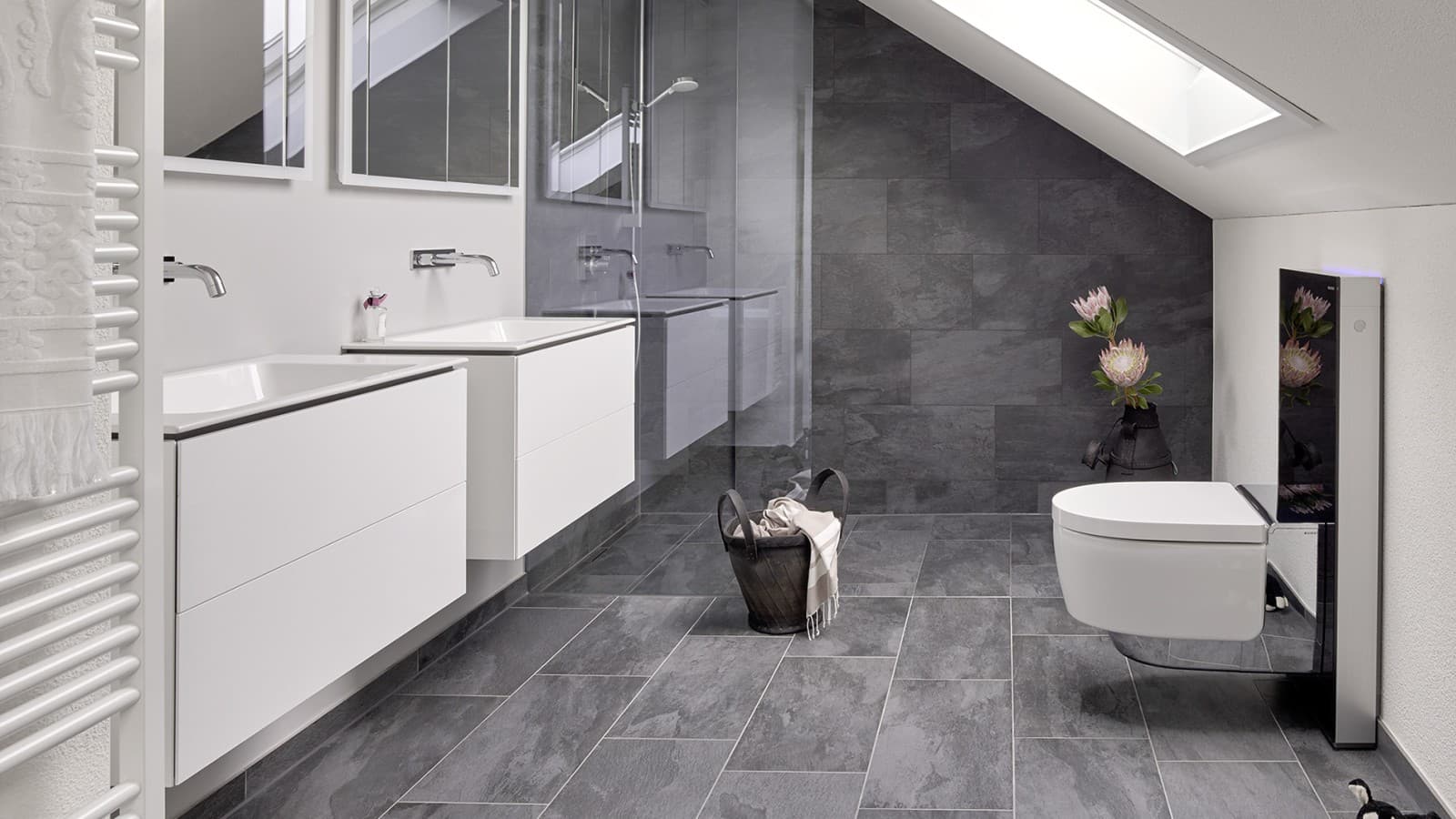 Badkamer met schuin plafond en producten uit de Geberit ONE badkamerserie en Geberit AquaClean met Monolith Badkamer met schuin plafond en producten uit de Geberit ONE badkamerserie en Geberit AquaClean met Monolith